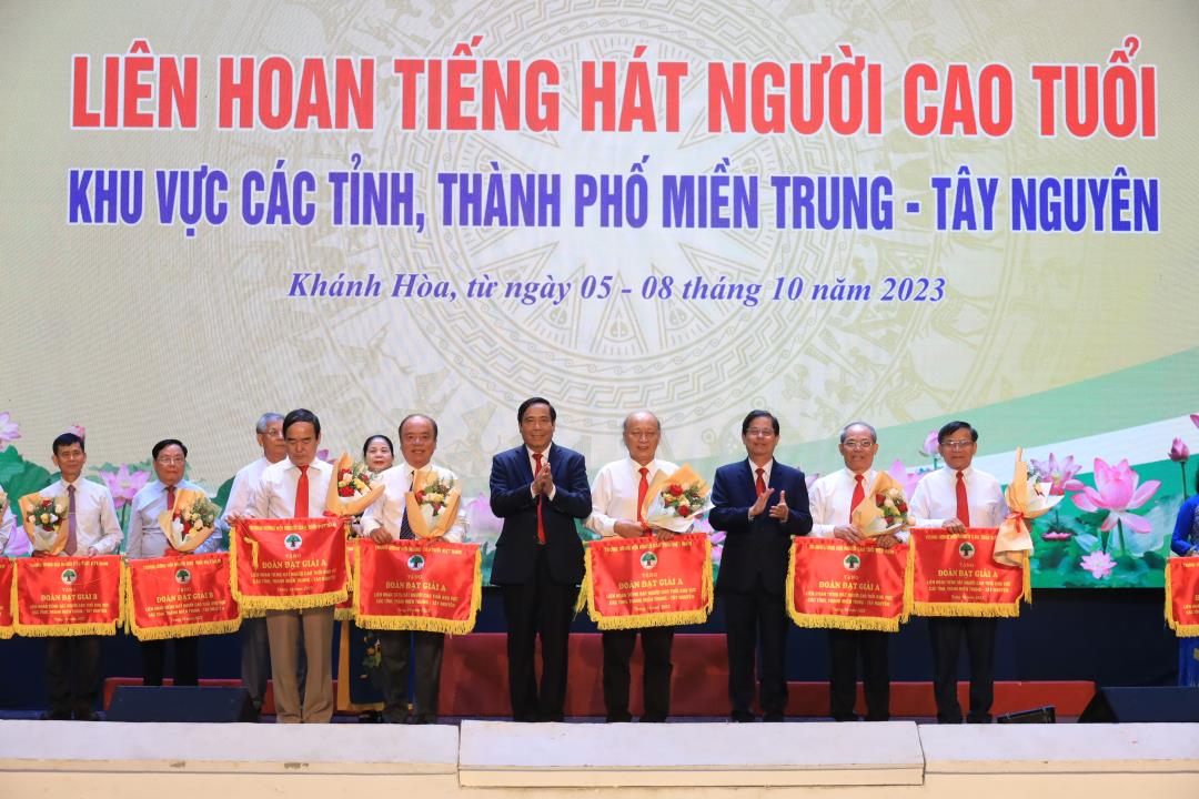 Ông Nguyễn Thanh Bình- Chủ tịch Hội Người cao tuổi Việt Nam (thứ 5 từ trái sang) và ông Nguyễn Tấn Tuân- Chủ tịch UBND tỉnh Khánh Hòa (thứ 7 từ trái sang) trao giải A toàn đoàn cho đại diện đoàn nghệ thuật người cao tuổi các địa phương.