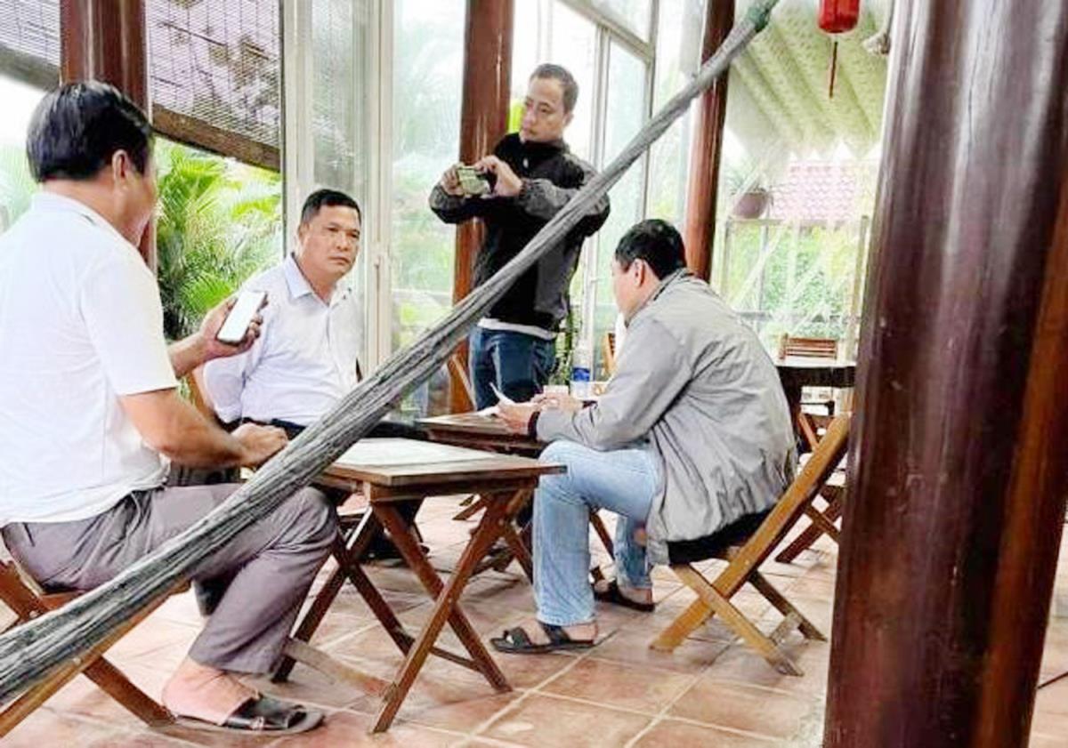 Đặng Ngọc Bảo (thứ 2 từ trái sang) bị bắt quả tang đang nhận tiền doanh nghiệp tại quán cà-phê.