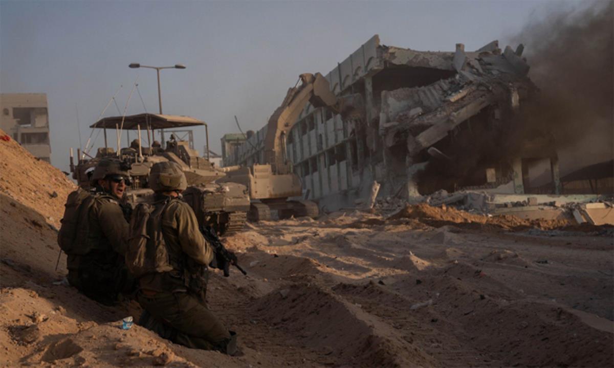 Binh sĩ, xe tăng, máy xúc của Israel đang phá một tòa nhà ở Dải Gaza ngày 7-11. Ảnh: IDF