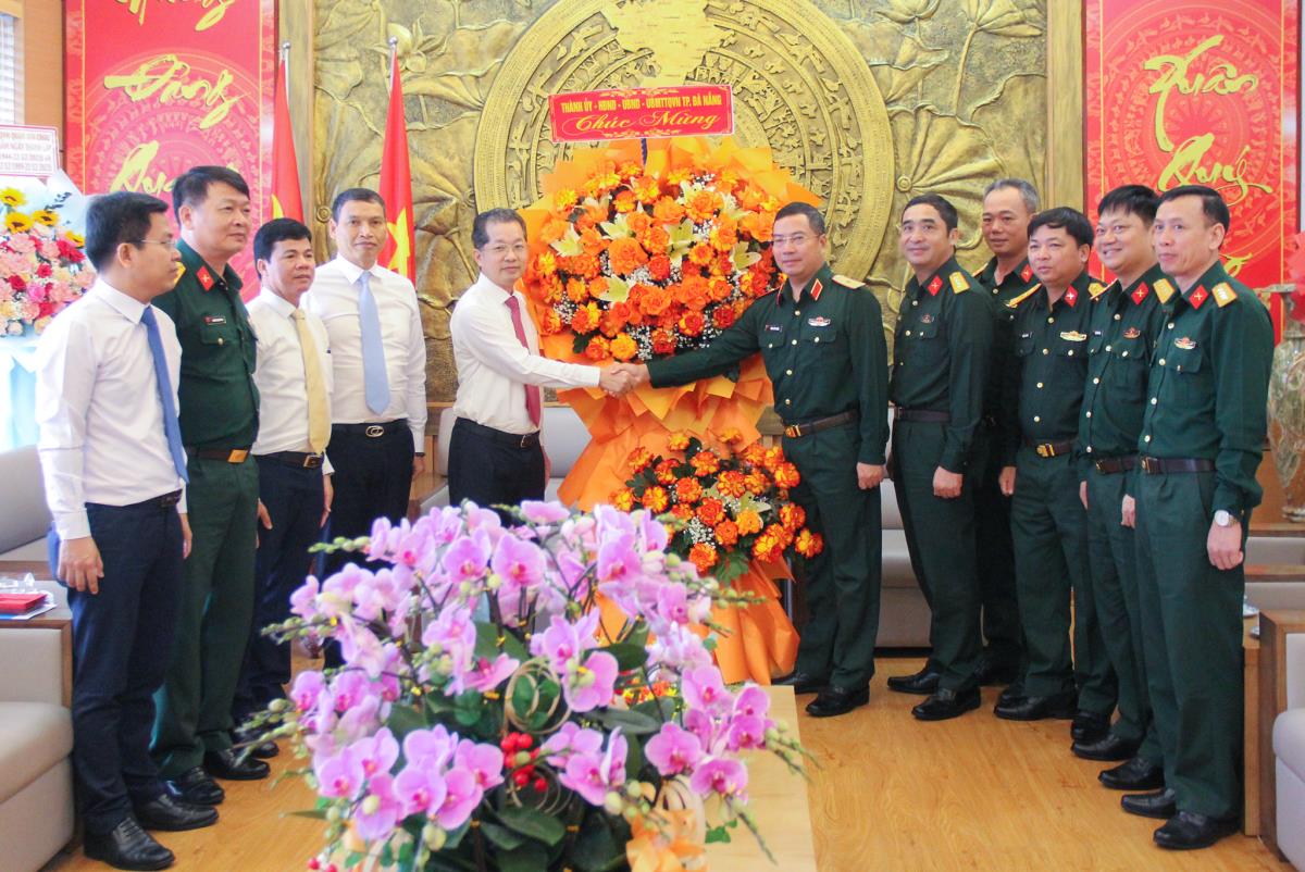 Bí thư Thành ủy Nguyễn Văn Quảng (thứ 3, từ trái sang) tặng hoa chúc mừng Trung đoàn Bộ binh 971