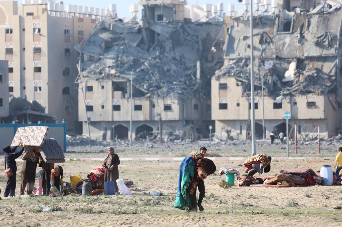 Người dân Palestine mang vác đồ đạc sau khi Israel không kích các tòa nhà dân cư ở thị trấn Khan Younis, miền Nam Gaza ngày 2-12. Ảnh: Reuters