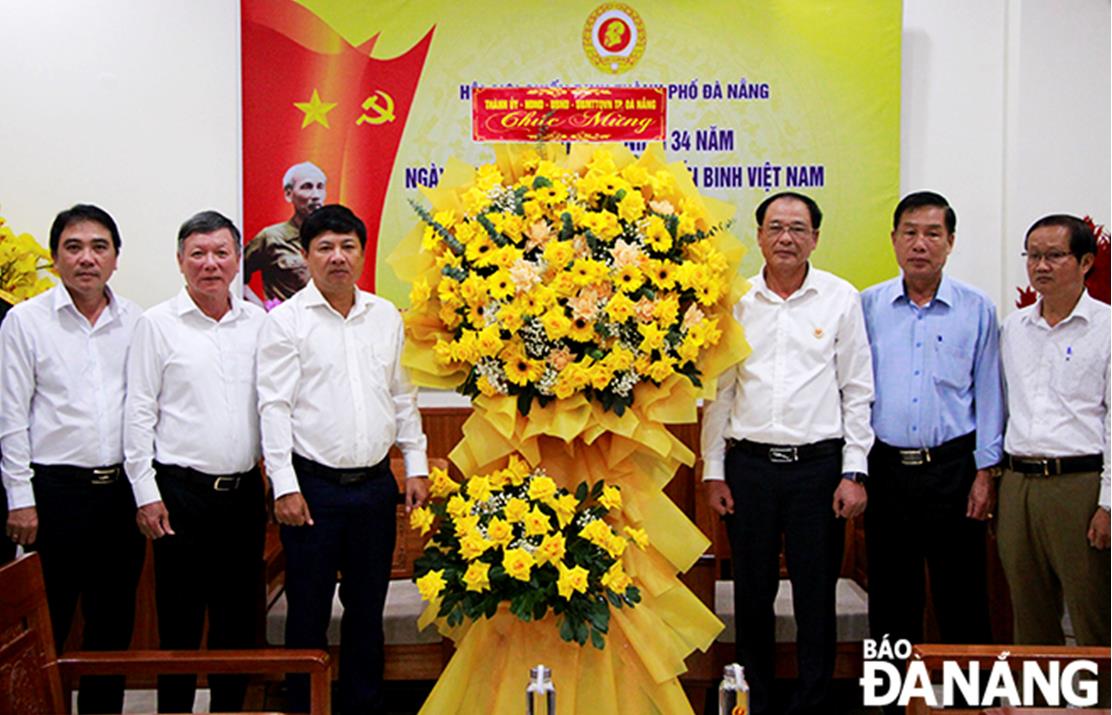 Phó Bí thư Thường trực Thành ủy Lương Nguyễn Minh Triết (thứ 3, bên trái sang) tặng hoa chúc mừng Hội Cựu chiến binh thành phố nhân kỷ niệm 34 năm ngày thành lập Hội Cựu chiến binh Việt Nam.