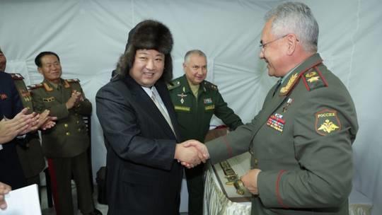 Nhà lãnh đạo Triều Tiên Kim Jong-un đội mũ ushanka của Nga, bắt tay Bộ trưởng Quốc phòng Nga Sergey Shoigu. Ảnh: KCNA