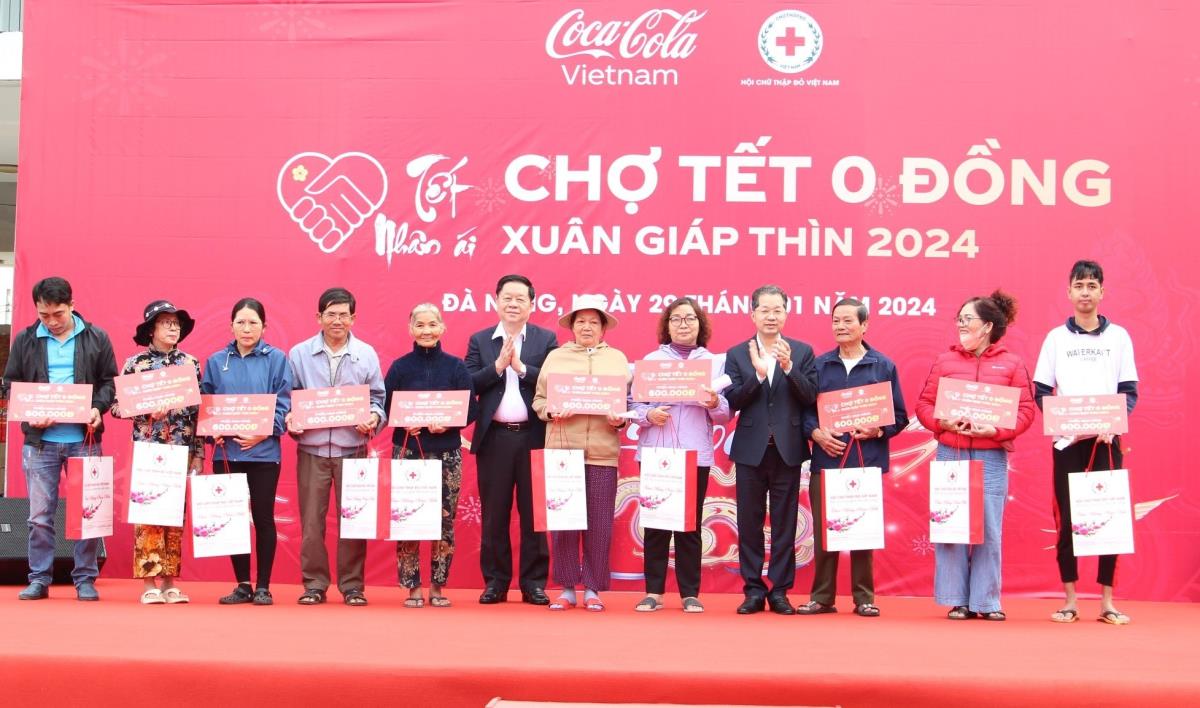 Bí thư Thành ủy Nguyễn Văn Quảng (giữa) trao quà Tết cho hộ khó khăn tại quận Cẩm Lệ.