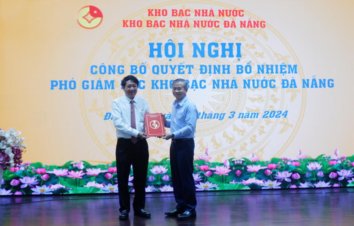 Thừa ủy quyền của Tổng Giám đốc Kho bạc Nhà nước Việt Nam, Phó Tổng Giám đốc Kho bạc Nhà nước Việt Nam Nguyễn Quang Vinh (phải) trao quyết định bổ nhiệm ông Lê Thanh Tùng, Giám đốc Kho bạc Nhà nước Sơn Trà giữ chức Phó giám đốc Kho bạc Nhà nước Đà Nẵng.