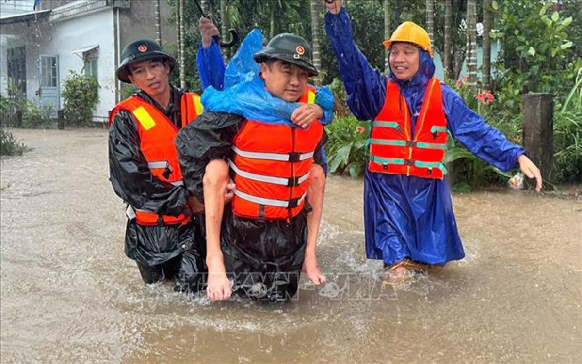 Lực lượng bộ đội và dân quân xã Duy Xuyên, thành phố Đà Nẵng giúp dân vùng lũ. Ảnh: Trần Tĩnh/TTXVN