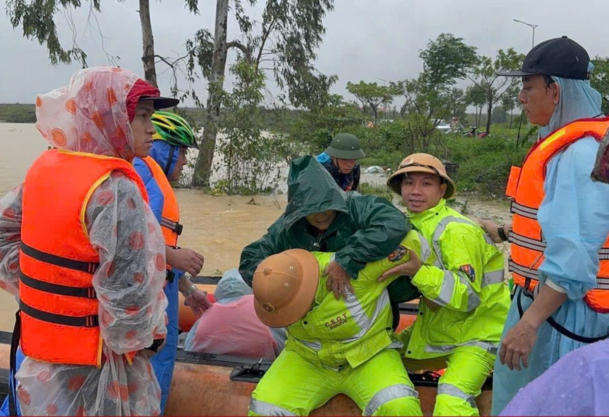 Lực lượng CSGT Công an TP Đà Nẵng dùng xuồng máy đưa một người dân từ vùng ngập sâu đến nơi an toàn.