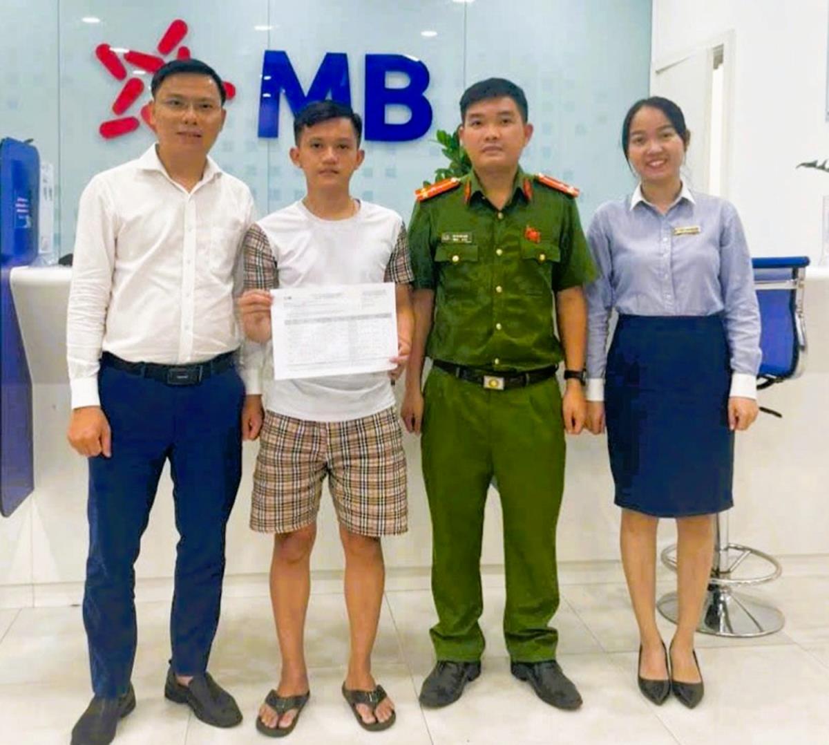 Anh Thành (thứ 2 bên trái) hoàn tất việc chuyển trả số tiền cho người chuyển nhầm.