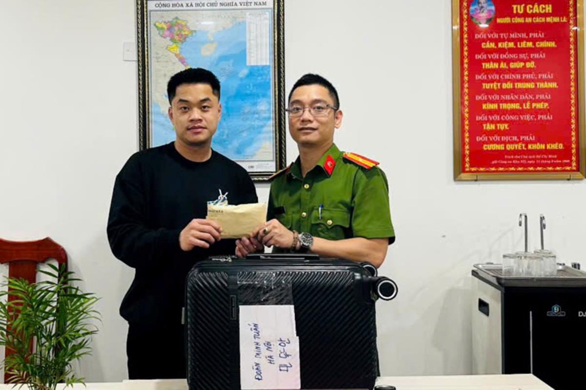 Cán bộ Công an phường Sơn Trà bàn giao chiếc ĐTDĐ cho anh Tilan Shan.