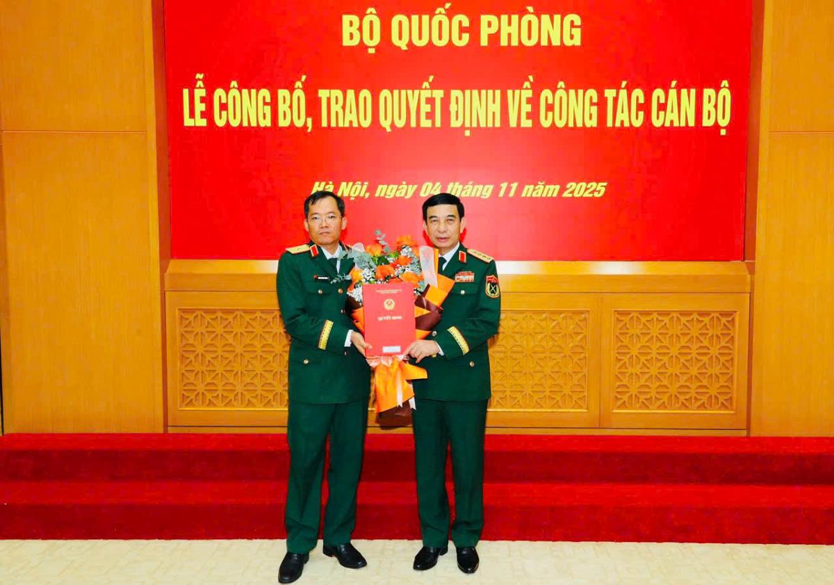 Đại tướng Phan Văn Giang (phải) trao quyết định và tặng hoa chúc mừng Thiếu tướng Lương Đình Chung