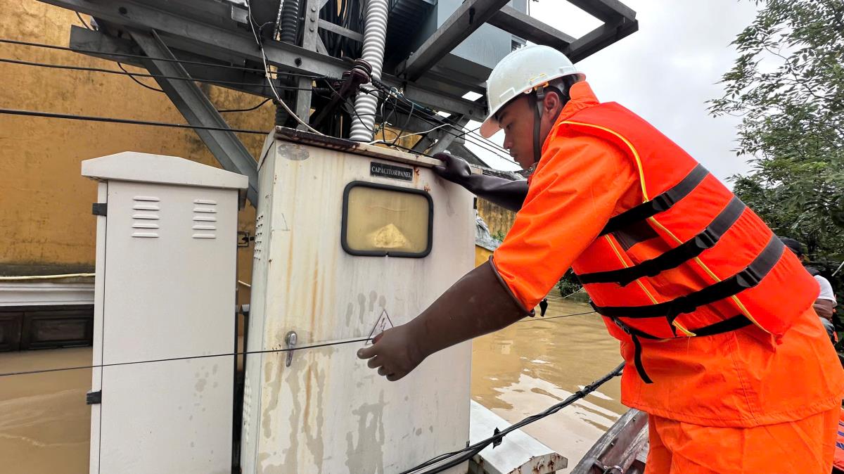 Nhân viên EVNCPC khắc phục sự cố điện do mưa lũ.