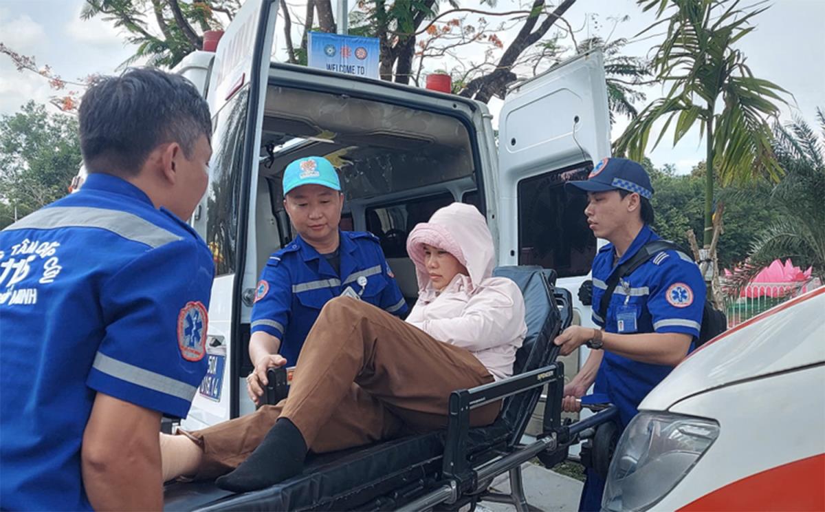 Các y bác sĩ Trung tâm Cấp cứu 115 chuyển người bị say nắng trong quá trình chiêm bái xá lợi Đức Phật Thích Ca Mâu Ni tại chùa Thanh Tâm lên xe cứu thương.