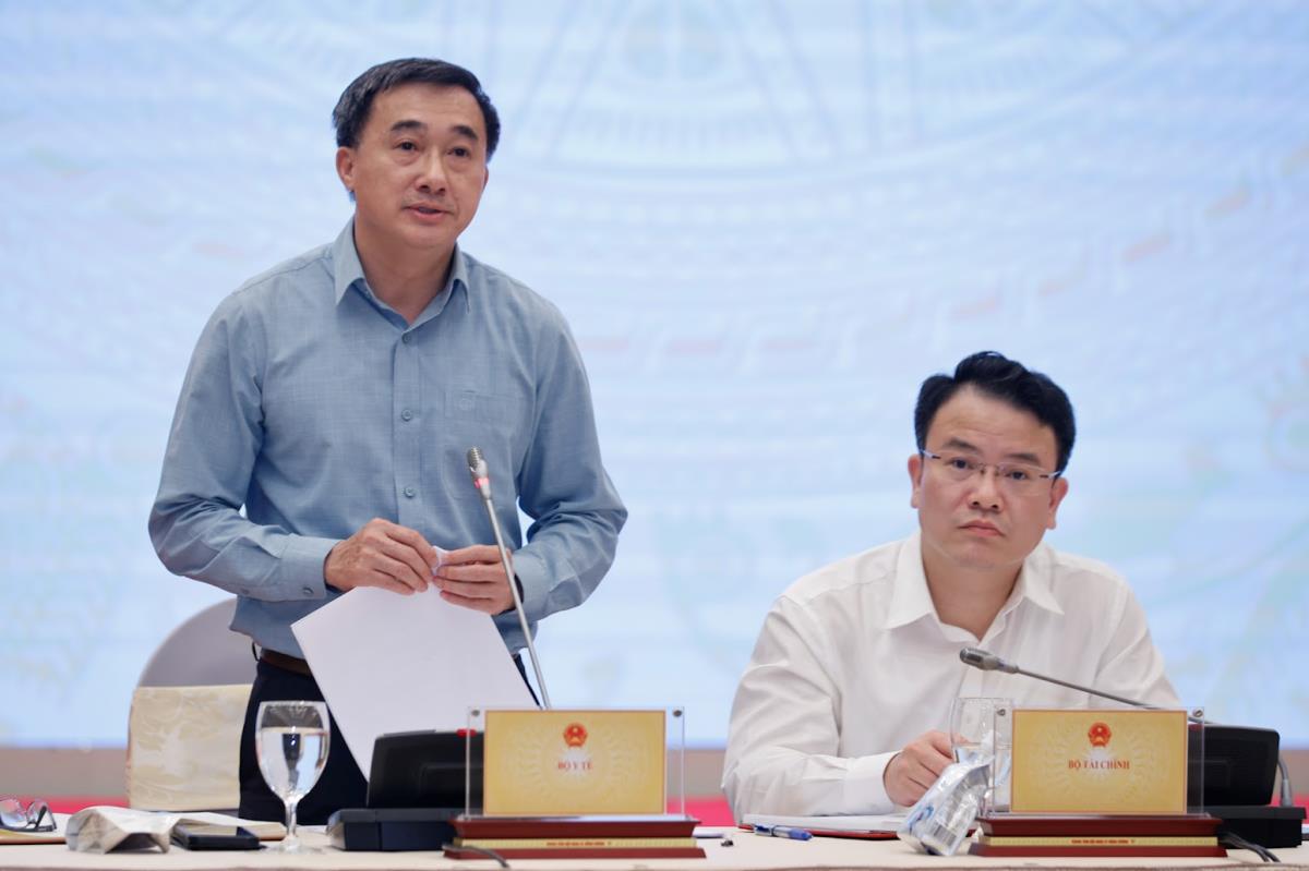 Thứ trưởng Bộ Y tế Trần Văn Thuấn (trái) cung cấp thông tin về việc thực hiện chủ trương miễn viện phí cho toàn dân.