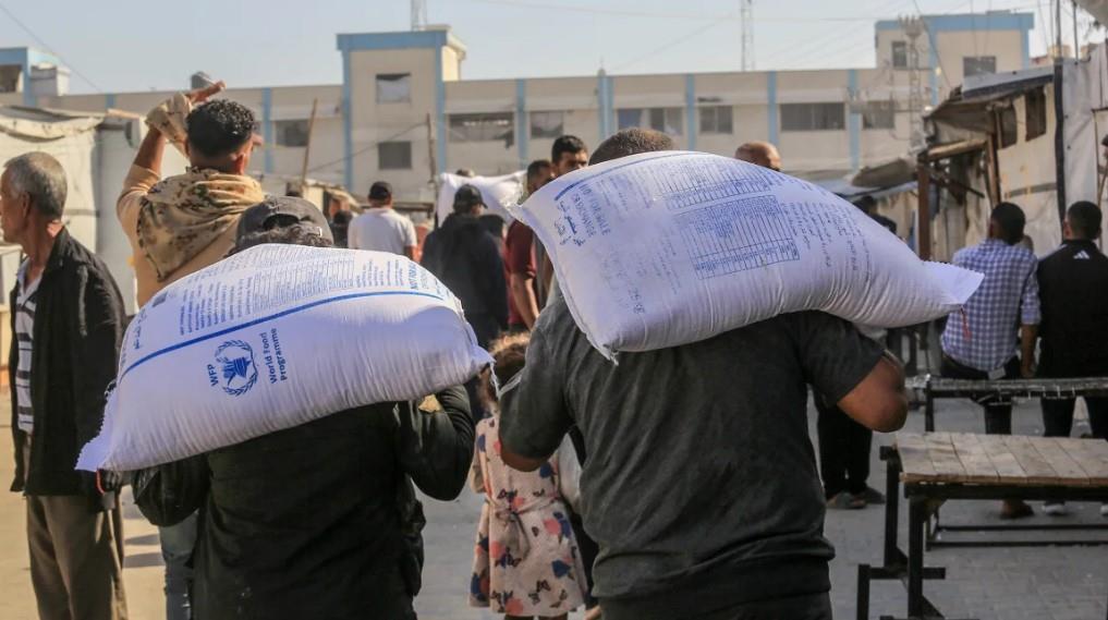 Người dân mang theo những bao bột mì do các tổ chức từ thiện phân phát ở Khan Younis, Gaza ngày 21-5. Ảnh: Getty Images