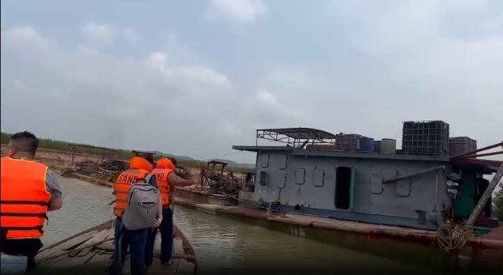 Lực lượng Công an làm việc với các đối tượng liên quan tại thời điểm kiểm tra, bắt giữ các tàu hút cát trái phép trên sông Lam.