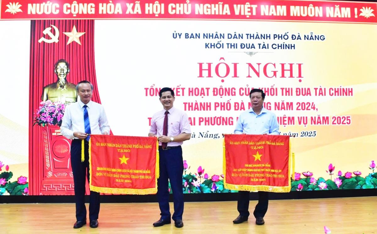 Phó Chủ tịch HĐND TP Đoàn Ngọc Hùng Anh (người ngoài cùng bên trái) tặng “Cờ Đơn vị dẫn đầu phong trào thi đua” của Chủ tịch UBND TP Đà Nẵng cho 2 đơn vị.