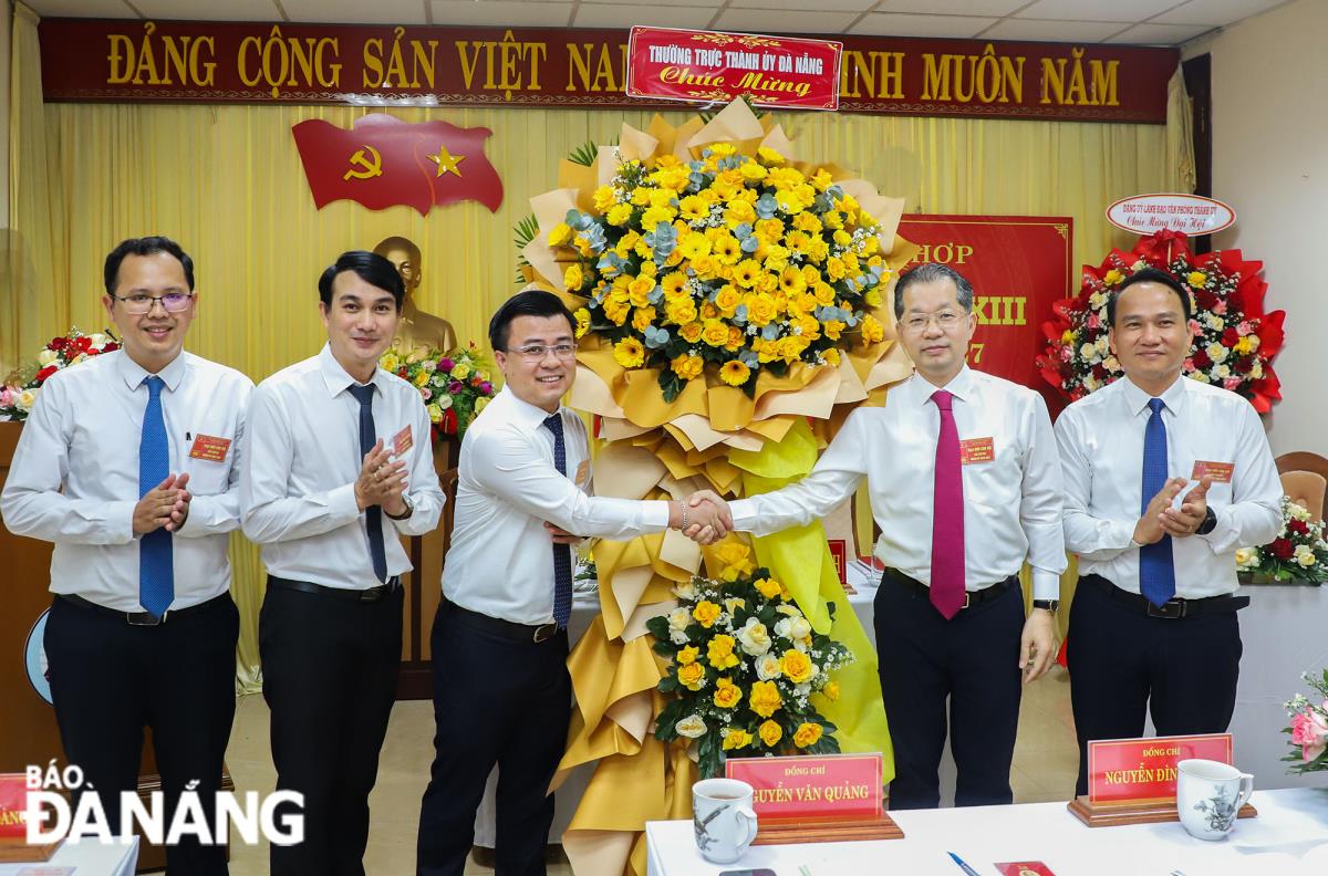 Bí thư Thành ủy Nguyễn Văn Quảng (thứ 2, phải sang) và Phó Bí thư Thường trực Thành ủy Nguyễn Đình Vĩnh (bên phải) tặng hoa chúc mừng đại hội.