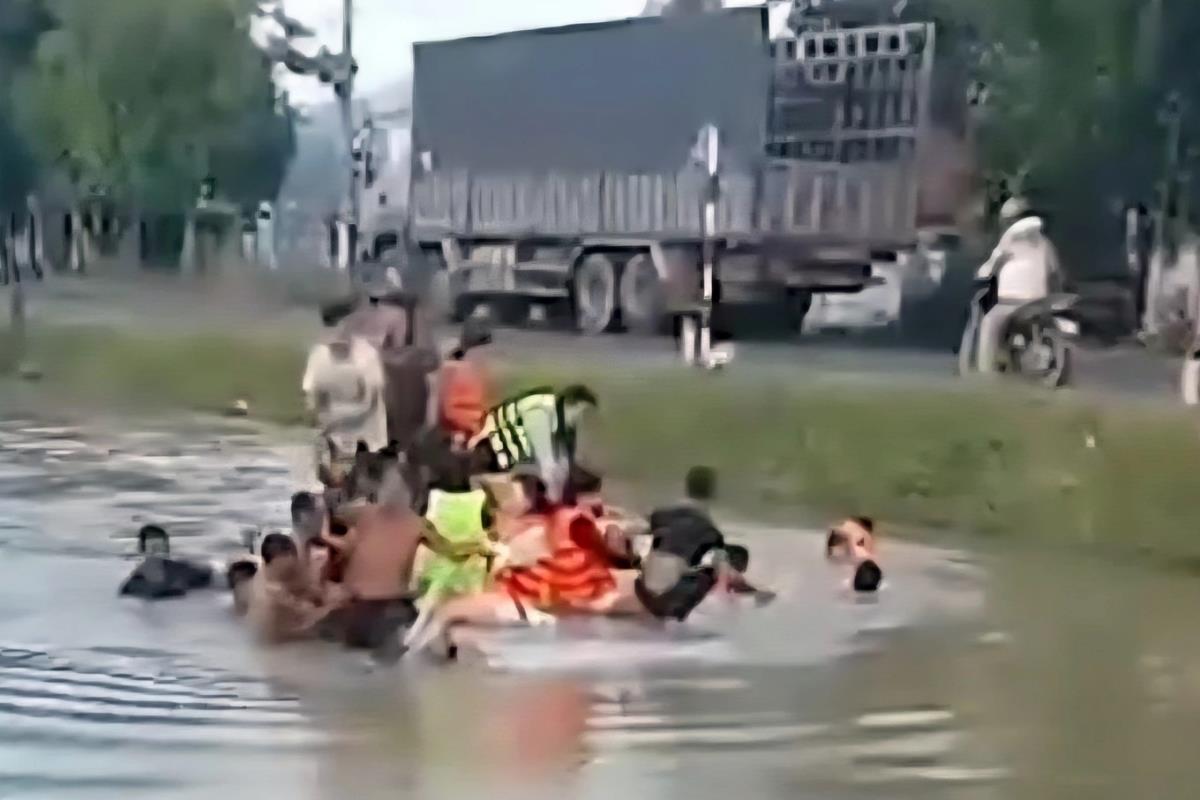 Người dân ở xã Hòa Định Tây ứng cứu các nạn nhân trên ô tô 16 chỗ rơi xuống mương nước (Ảnh: Loan Thanh).