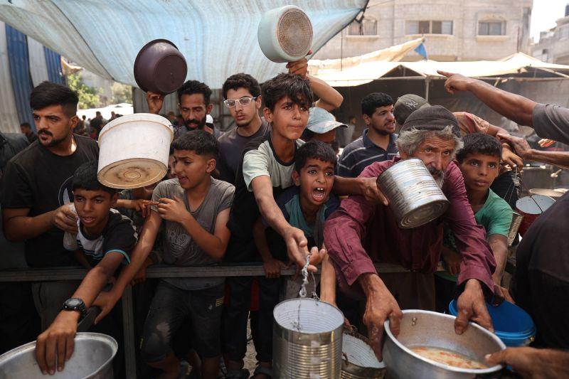 Trẻ em Palestine xếp hàng nhận một phần thức ăn do bếp ăn từ thiện phân phát tại trại tị nạn Nuseirat ở miền trung Dải Gaza ngày 15-7. Ảnh: AFP