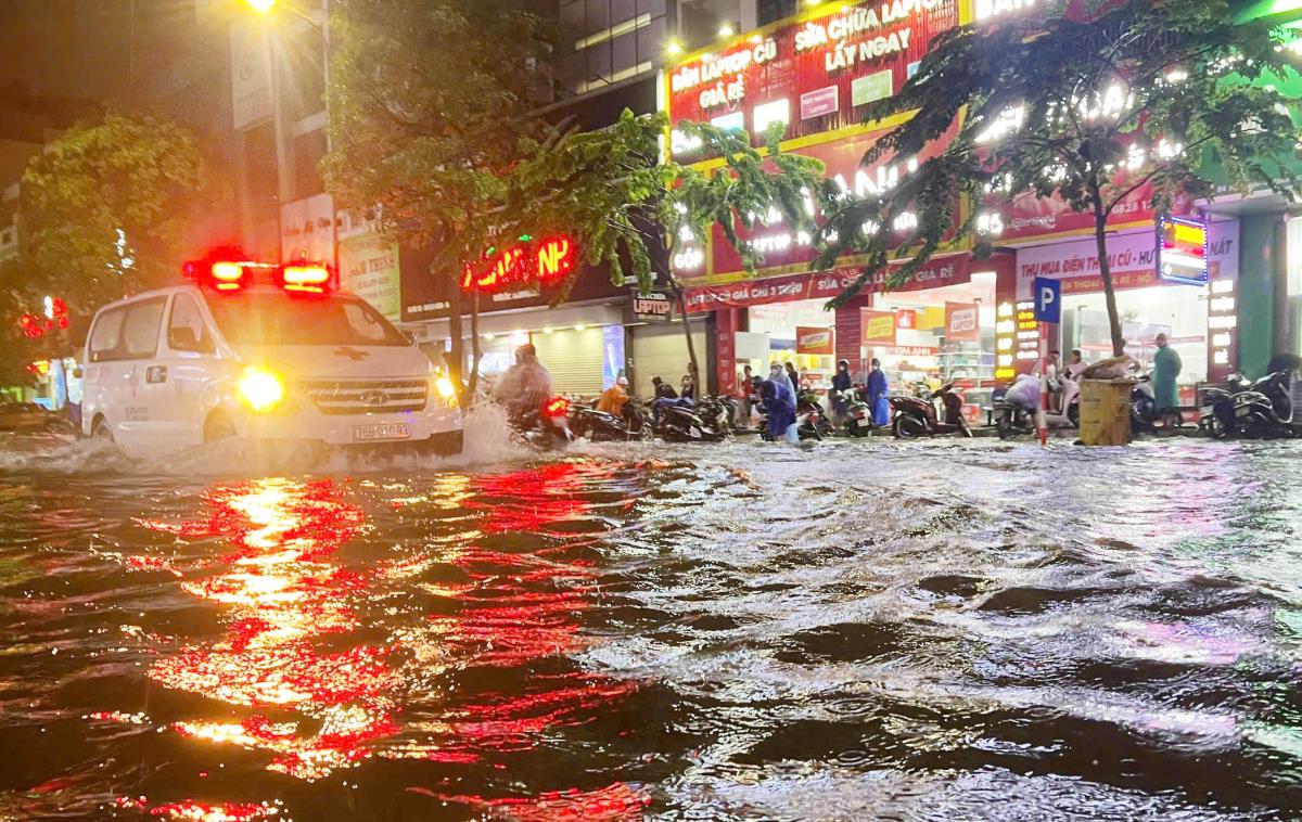 Một tài xế lái xe ô tô đi tìm chỗ đậu trên cao tránh bị ngập nước