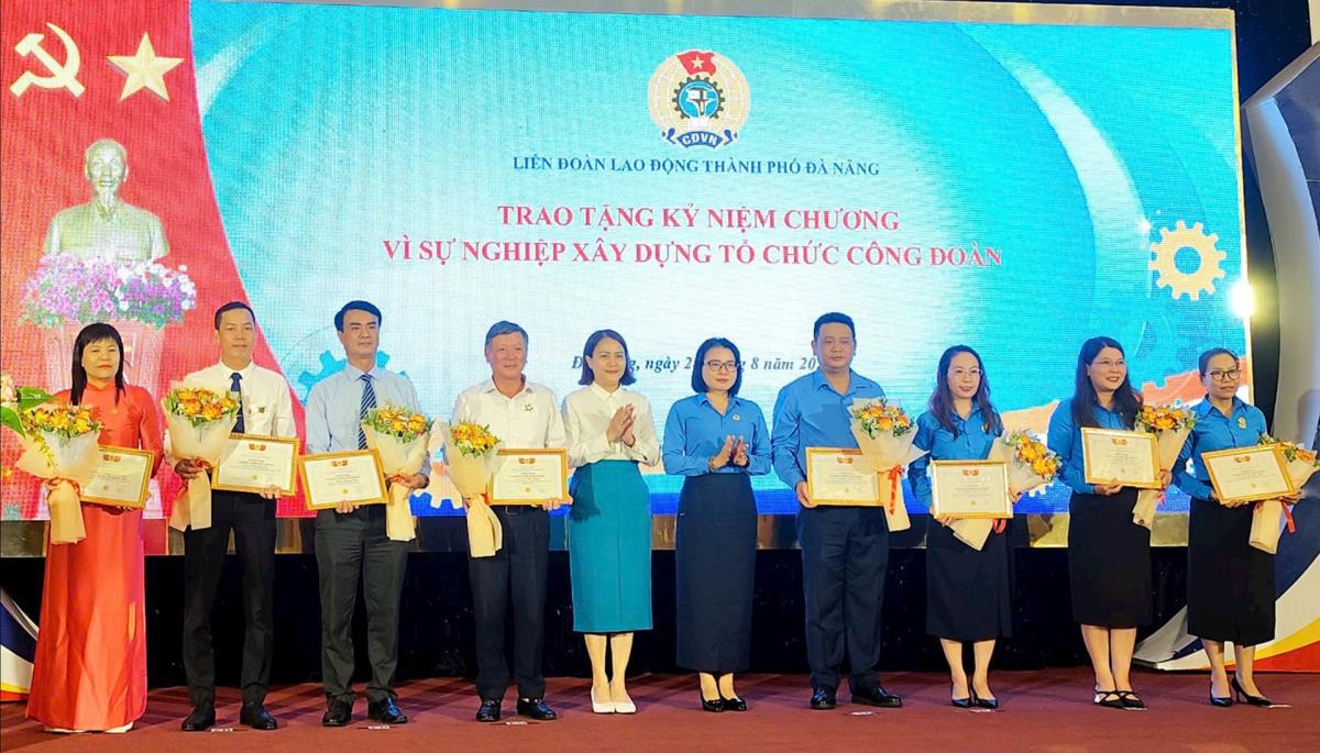 Chủ tịch Liên đoàn Lao động thành phố Phan Thị Thúy Linh (thứ 5, bên phải sang) và Phó Chủ tịch Ủy ban MTTQ Việt Nam thành phố Trần Thị Mẫn (thứ 5, bên trái sang) trao Kỷ niệm chương cho các cá nhân.