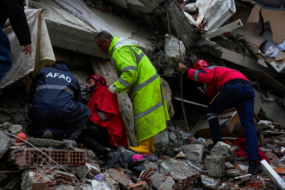 Bộ trưởng Y tế Thổ Nhĩ Kỳ Fahrettin Koca cho hay, thời tiết và quy mô của thảm họa động đất đang tạo ra những thách thức cho các nhóm cứu hộ khi khó tiếp cận nhiều khu vực bị đổ nát. (Trong ảnh: Các đội khẩn cấp tìm kiếm nạn nhân trong đống đổ nát của một tòa nhà bị sập ở Adana, Thổ Nhĩ Kỳ).
