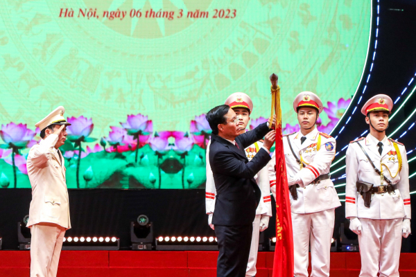 Chủ tịch nước Võ Văn Thưởng gắn Huân chương Bảo vệ Tổ quốc hạng Nhất lên Cờ truyền thống của Lực lượng Xây dựng lực lượng CAND.
