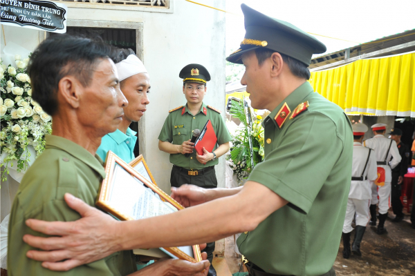 Thứ trưởng Lương Tam Quang trao Quyết định của Bộ trưởng Bộ Công an truy thăng cấp bậc hàm trước niên hạn và Quỹ “nghĩa tình đồng đội Công an nhân dân” cho gia đình thân nhân các đồng chí Công an xã. 