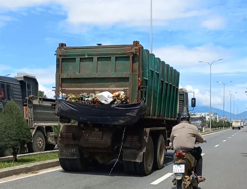 Sắp tới Đà Nẵng sẽ "khai tử" các xe chở rác hư hỏng, xuống cấp, gây ô nhiễm trong quá trình thu gom, vận chuyển. Trong ảnh: Một xe thu gom rác vừa cơi nới đựng rác bằng bạt vừa rỉ nước trên đường vận chuyển.