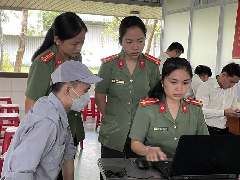 Cán bộ chiến sĩ Phòng Quản lý xuất nhập cảnh Công an tỉnh Quảng Nam hướng dẫn cụ thể cho công nhân đăng ký cấp hộ chiếu phổ thông trực tuyến.