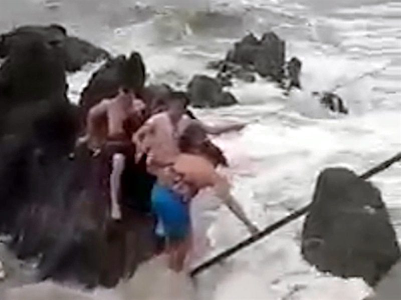 Lực lượng cứu hộ đưa du khách gặp nạn lên bờ. (ảnh cắt từ clip)