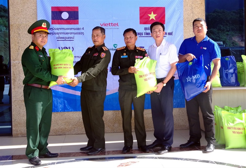 Đại tá Nguyễn Đình Độ (bên trái) - Phó Chỉ huy trưởng Bộ CHQS tỉnh Thừa Thiên Huế và lãnh đạo các đơn vị Viettel, MB trao gạo tặng Bộ CHQS tỉnh Salavan, Sêkông (Lào).
