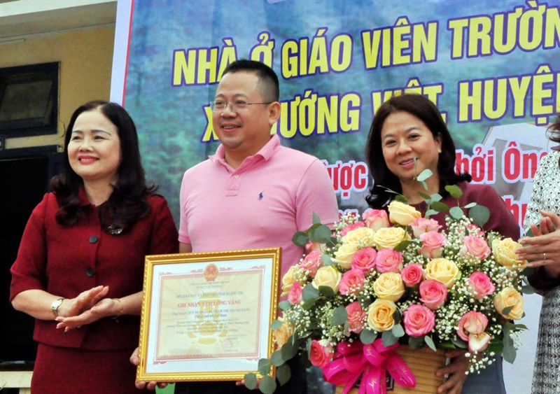 Giám đốc Sở GD – ĐT Quảng Trị (phía trái) trao Bảng ghi nhận Tấm lòng vàng cho gia đình anh Dương - chị Hằng.