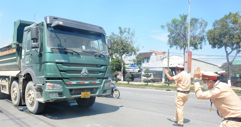 Lực lượng CSGT Trạm cửa ô Hòa Nhơn hướng dẫn tài xế đưa xe lên cân tải trọng, nhắc nhở tài xế xe tải ben và đo kích thước thành thùng xe vi phạm.