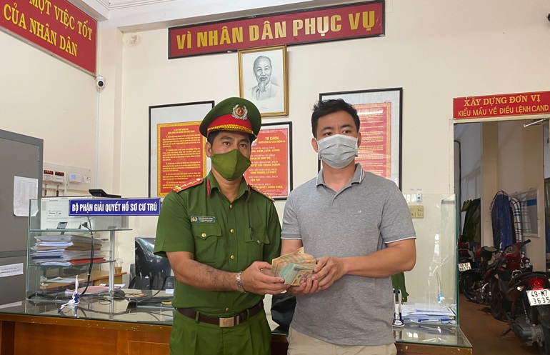 Đại úy Nguyễn Đức Dũng trao trả số tiền cho anh Đ.Q.A.