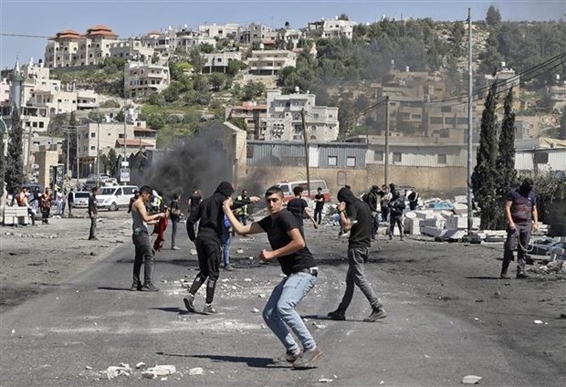 Người biểu tình Palestine ném đá về phía cảnh sát Israel trong cuộc đụng độ tại khu vực Đền Al-Aqsa ở Đông Jerusalem ngày 15-4. Ảnh: AFP