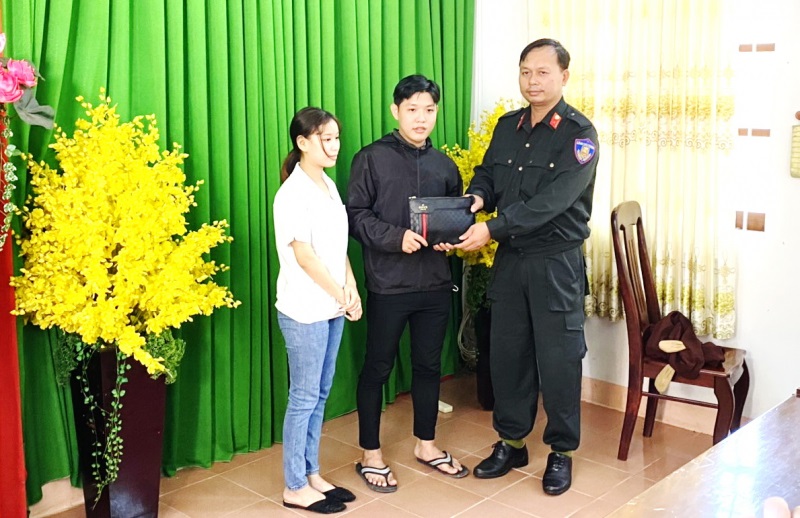 Thiếu tá Nguyễn Đình Quang trao lại tài sản cho chị Dương Thị Nguyệt Nga cùng người thân.