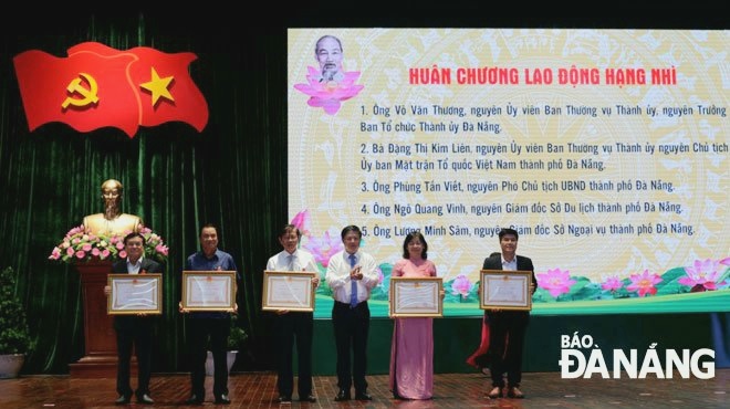 Chủ tịch UBND thành phố Lê Trung Chinh (giữa) trao Huân chương Lao động hạng Ba cho cho 12 cá nhân đã có thành tích xuất sắc trong quá trình công tác, góp phần vào sự nghiệp xây dựng chủ nghĩa xã hội và bảo vệ Tổ quốc.