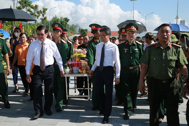 Nguyên Chủ tịch nước Trương Tấn Sang, Phó Thủ tướng Vũ Đức Đam đưa hài cốt liệt sĩ mới được quy tập đến đài tưởng niệm để làm lễ truy điệu, an táng.