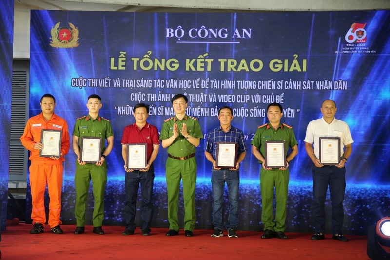 Thứ trưởng Bộ Công an Nguyễn Duy Ngọc trao giải thưởng cho các tác giả đạt giải cao cuộc thi ảnh nghệ thuật.