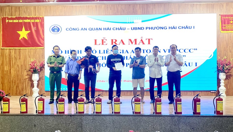 Thượng tá Lê Phước Cam và ông Võ Trường Anh trao quyết định thành lập "Tổ liên gia an toàn PCCC" và tặng hoa cho các hộ gia đình tham gia "Tổ liên gia an toàn PCCC".