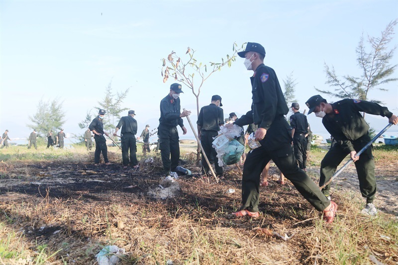 Lực lượng Cảnh sát Cơ động CATP Đà Nẵng chia thành nhiều nhóm để thu gom rác, làm sạch bãi biển.