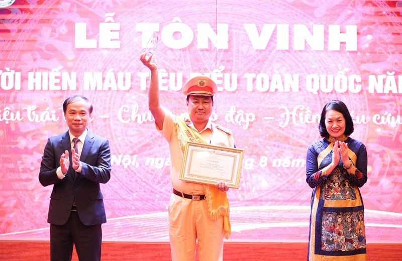 Trung tá Phan Quang Pháp thực hiện nhiệm vụ tuyên truyền an toàn giao thông cho người dân.