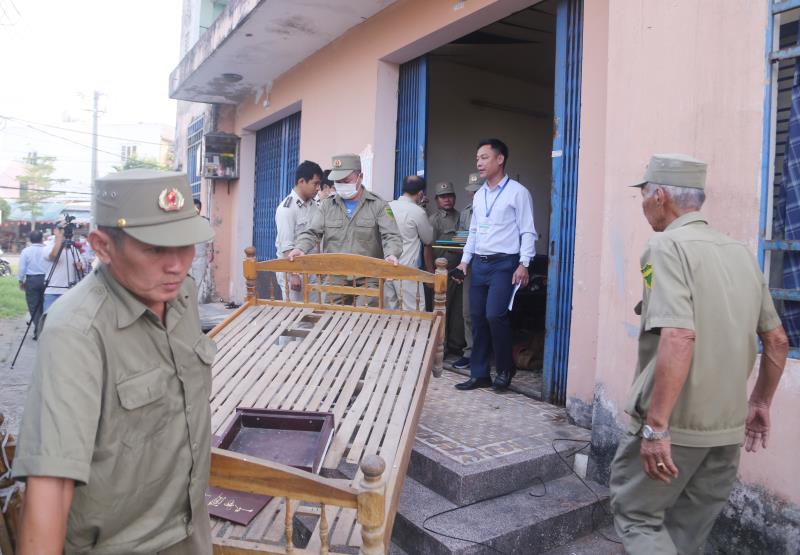 Lực lượng chức năng kiểm tra tài sản và lên phương án cưỡng chế thu hồi một căn hộ tại chung Làng cá Nại Hiên Đông