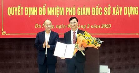 Phó Chủ tịch UBND thành phố Đà Nẵng Lê Quang Nam (trái) trao quyết định bổ nhiệm và chúc mừng ông Lê Văn Tuấn