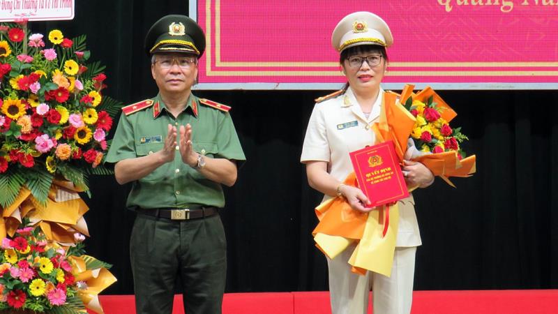 Thừa ủy nhiệm Thiếu tướng Nguyễn Đức Dũng trao Quyết định của Bộ trưởng Bộ Công an cho Thượng tá Võ Thị Trinh.