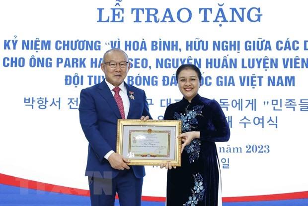 Chủ tịch Liên hiệp các tổ chức hữu nghị Việt Nam Nguyễn Phương Nga trao Kỷ niệm chương cho ông Park Hang-seo. Ảnh: TTXVN