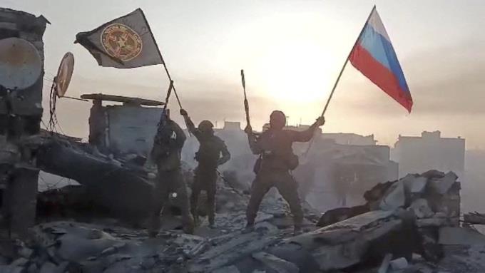 Lực lượng Wagner giương cờ Nga và cờ Wagner trên một tòa nhà đổ nát trong video công bố ngày 20-5. Ảnh: Reuters