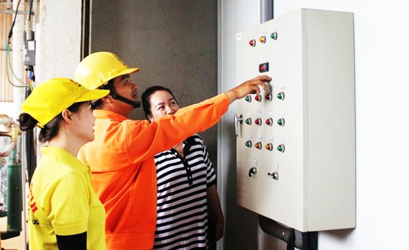 Công nhân ngành Điện thực hiện công tác tuyên truyền sử dụng tiết kiệm điện.