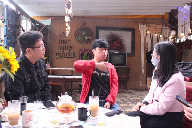 Nhân viên của Lặng Art Nguyễn Lương Quang (áo đỏ) đang trao đổi cùng khách.